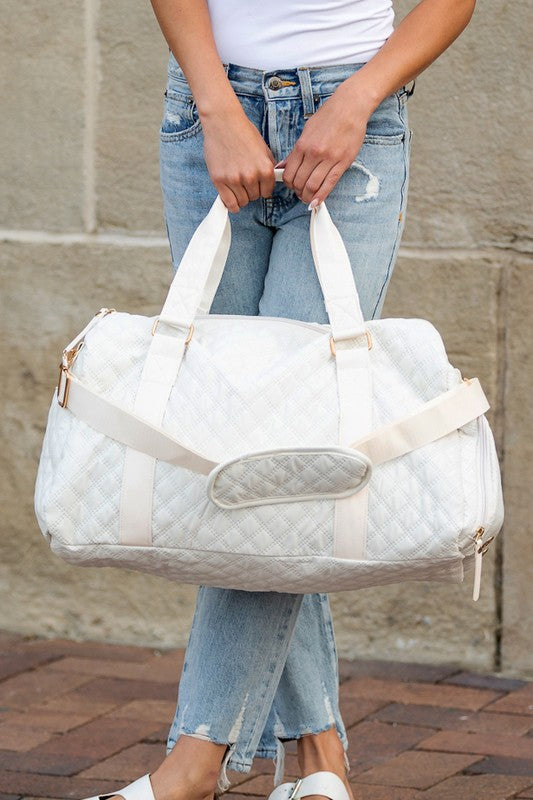 Woman holding white quilted Travel and Duffle Bags with handles and shoulder strap outdoors