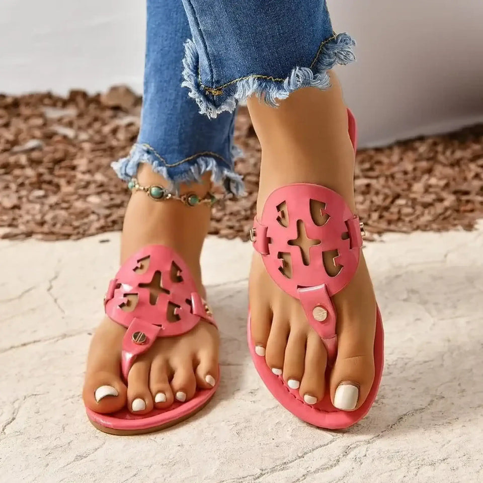 Woman wearing pink comfortable summer shoes for women with cutout designs and white pedicure