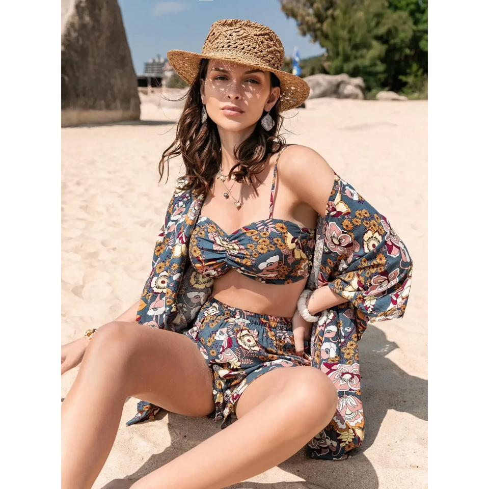 Woman wearing floral patterned Ladies Short Sets with matching cover-up and straw hat on sandy beach