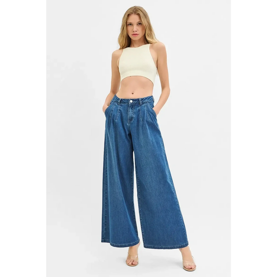 Woman wearing comfort casual denim jeans and shorts wide-leg blue jeans with a cropped top