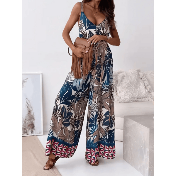 Trendsi Earth Toned Tropical Jumpsuit with wide legs and tropical leaf print worn with brown fringe bag