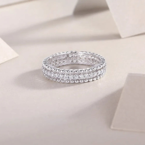 Babe Beachwear infinity Moissanite band ring with sparkling round-cut stones in silver setting