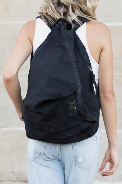 Babe Beachwaer Kai Asymetric Canvas Backpack in black worn by person in white tank top and jeans