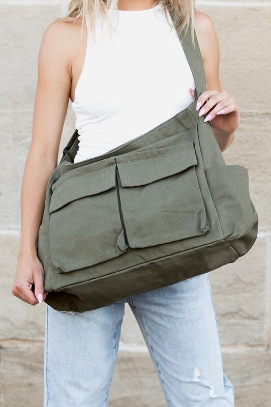Babe Beachwear Nova Oversized Canvas Messanger Bag in olive green worn over shoulder with multiple front pockets