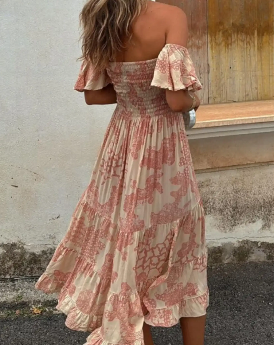 Trendsi smocked off shoulder midi dress with pink floral patterns and ruffled hem on model
