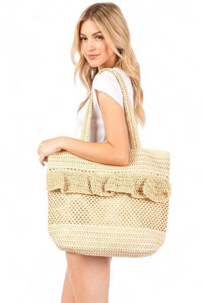 Artini Accessories uniqe ruffle straw bag carried by woman with long blonde hair in white outfit