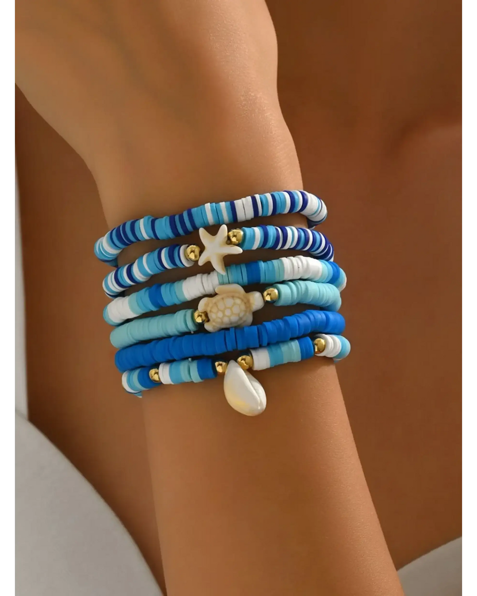 Trendsi blue stackable beach bracelets featuring beads and ocean-themed charms on wrist