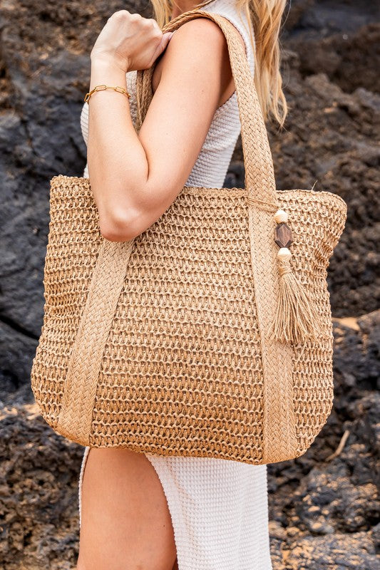 Chic classy woven khaki boho bag by Babe Beachwaer with tassel detail carried on shoulder