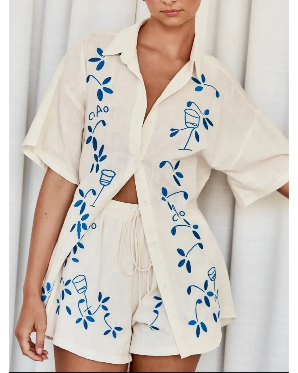 Trendsi embroidered shorts set for women featuring a cream button-up shirt and matching shorts with blue floral embroidery