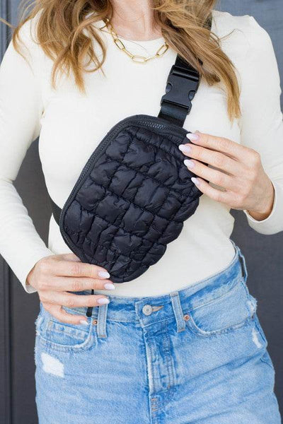 Lightweight Puffer Sling Bag in black worn by woman with white top and blue jeans