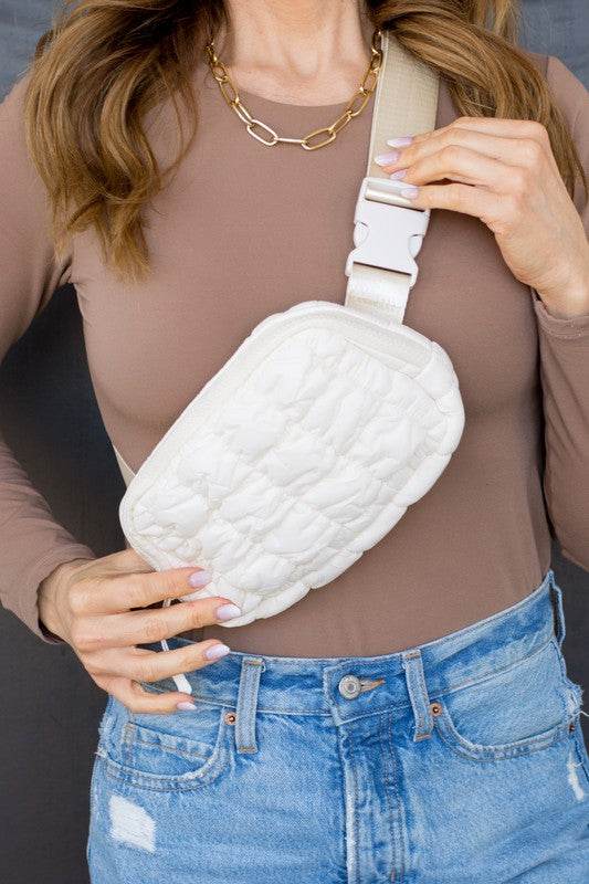 Babe Beachwear Lightweight Puffer Sling Bag in white worn with casual brown top and blue jeans