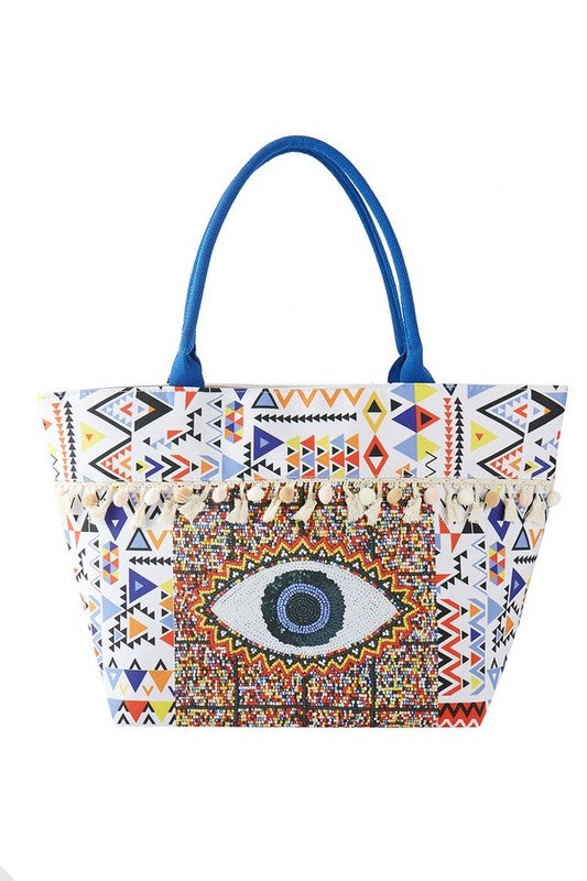 Babe Beachwear Pom Pom Evil Eye bag with colorful geometric patterns and blue handles