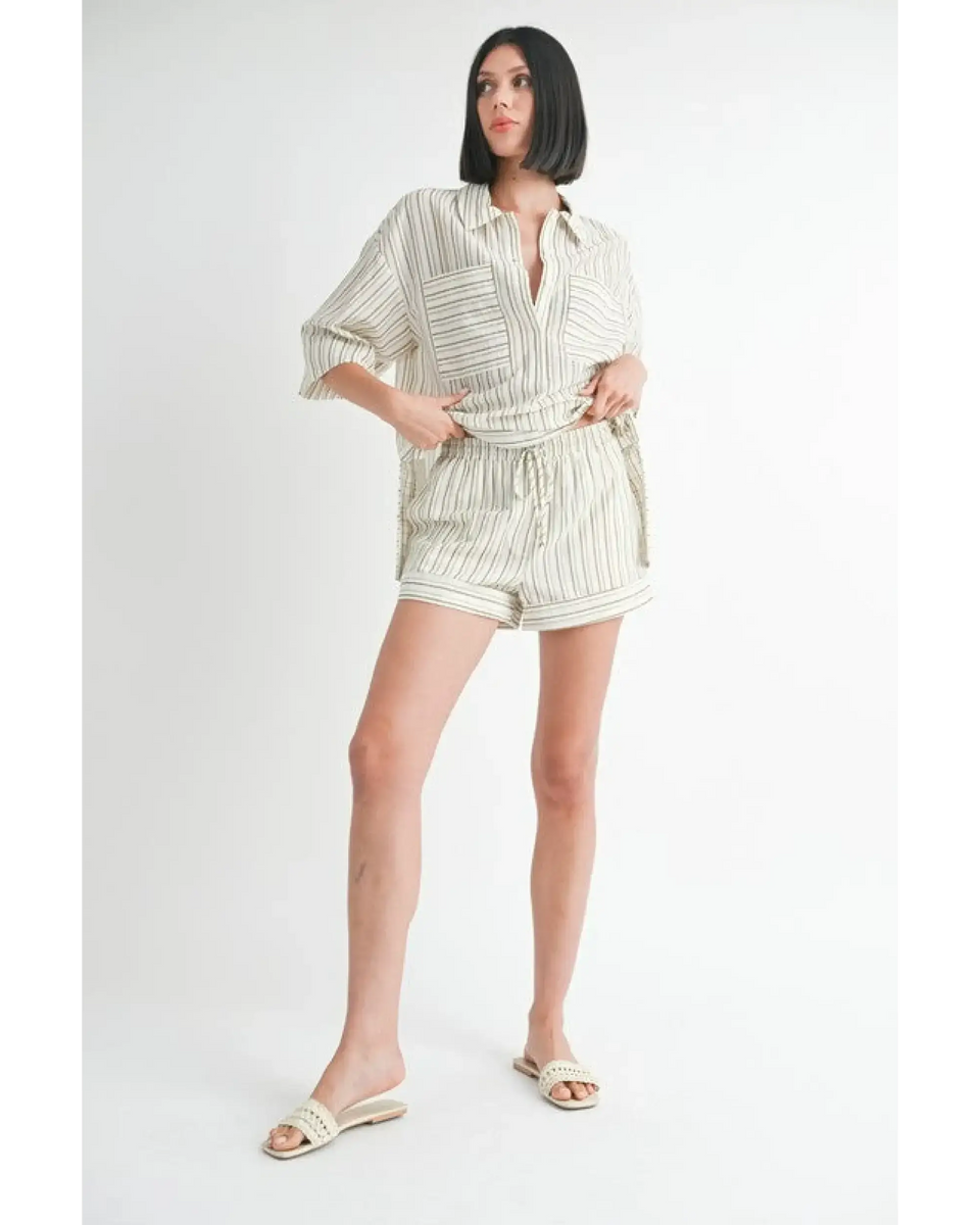 Woman wearing Emory Park women's linen shorts with a matching striped button-up shirt and slide sandals