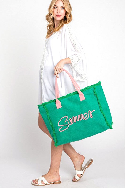 Woman carrying a large green tote bag with Summer 2025 Best Beach Bags printed on it