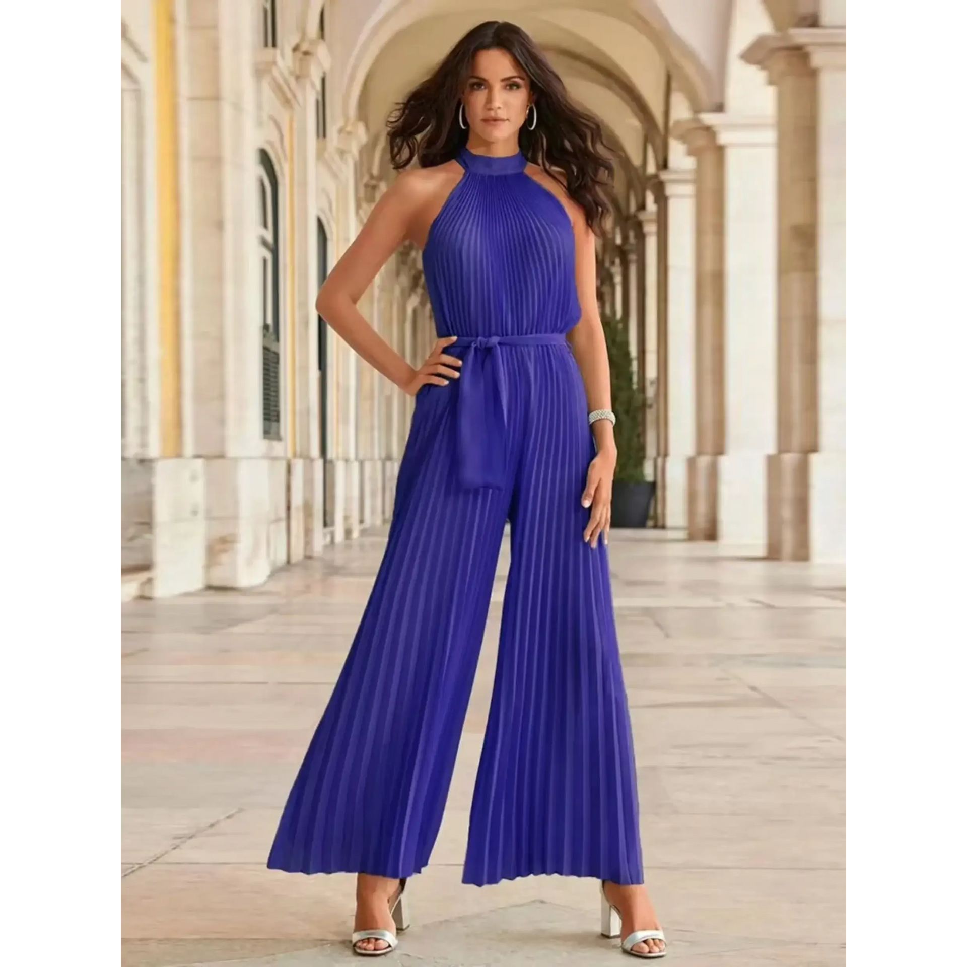 Woman wearing a sleeveless purple pleated jumpsuit showcasing classy resort wear for women with elegant style