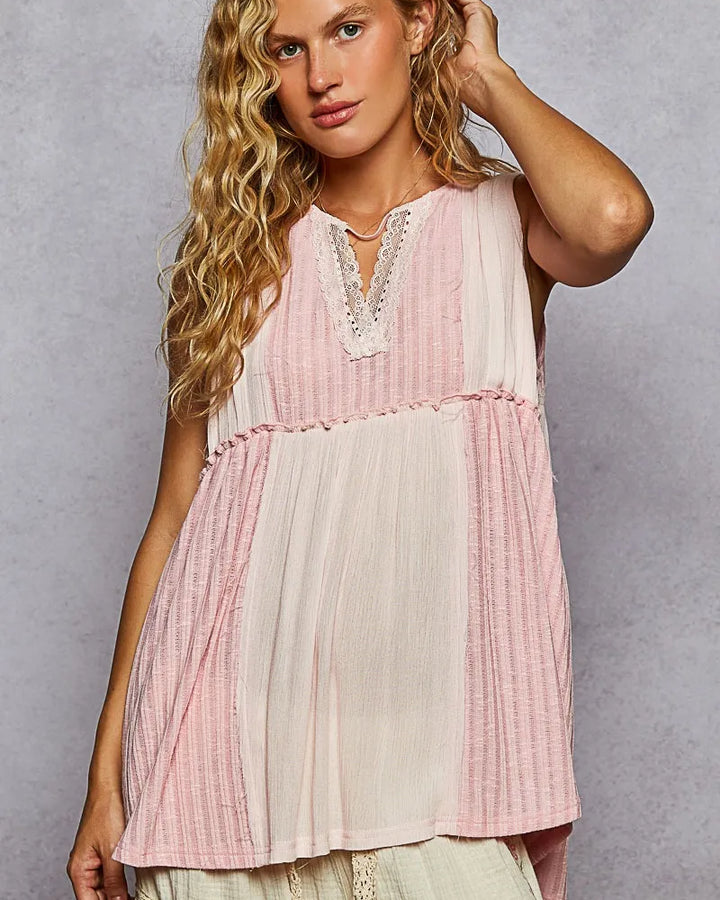 Woman wearing loose pink and cream short sleeve shirt with lace detailing and textured fabric