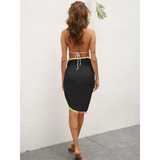 Beach Babes black coverup skirt with colorful pom pom trim worn by woman at the beach
