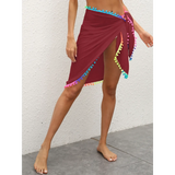 Beach Babes maroon coverup wrap skirt with multicolor pom pom trim on model's legs