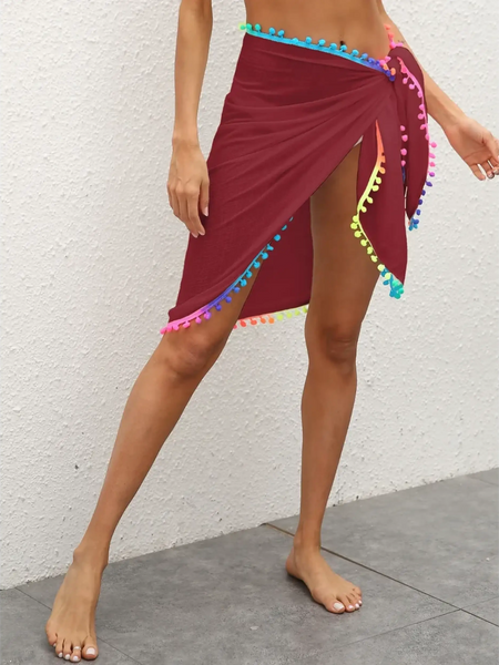 Beach Babes maroon coverup wrap skirt with multicolor pom pom trim on model's legs