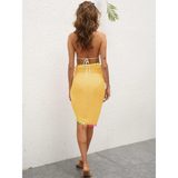 Beach Babes yellow coverup skirt with colorful pom pom trim worn by woman on beach