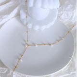 Trendsi 18K gold plated pearl necklace with delicate chain and small white pearls on white dish