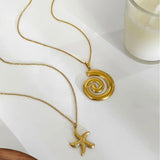 18k gold starfish necklace by Trendsi displayed alongside another gold spiral pendant necklace