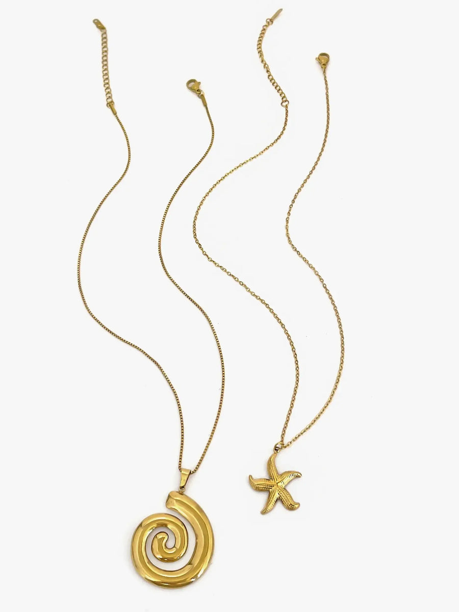 Elegant  18k gold starfish necklace displayed alongside a spiral shell pendant necklace on white background