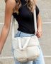 Babe Beachwaer Jacie Puffer Mini Tote in cream worn crossbody with quilted design and short handles