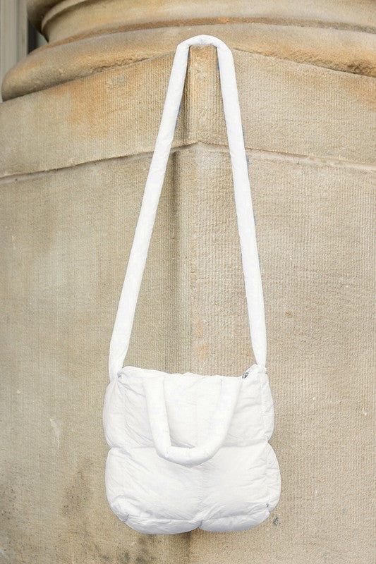Babe Beachwaer Jacie Puffer Mini Tote white quilted bag with long strap hanging on textured wall