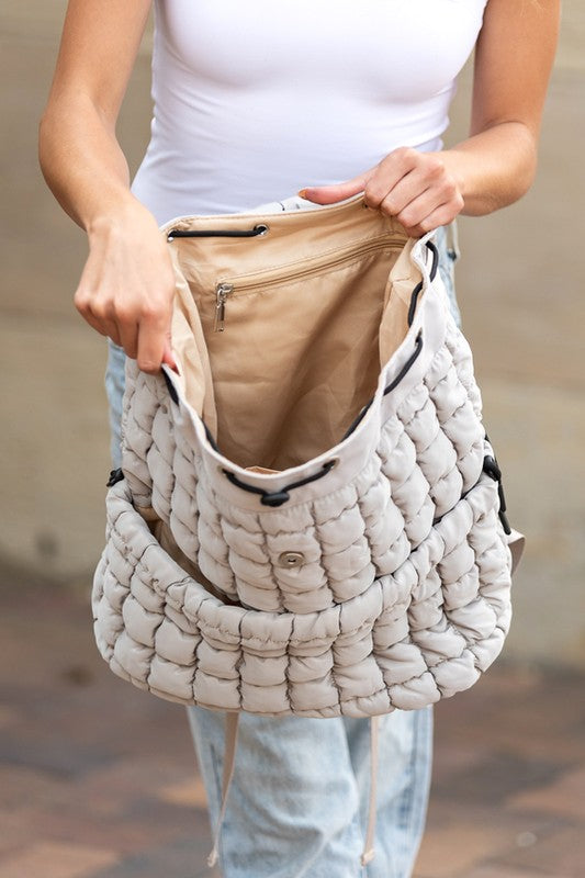 Babe Beachwear Puffer Backpack Lightweight in beige held open showing spacious interior with zippered pocket
