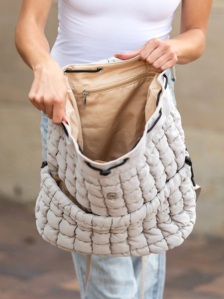 Babe Beachwear Puffer Backpack Lightweight in beige held open showing spacious interior with zippered pocket