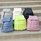 Babe Beachwear Puffer Backpack Lightweight collection in gray white black blue green and pink colors on stone steps
