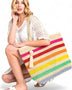 Woman holding large striped beach bag for women with colorful horizontal stripes and tassel detail