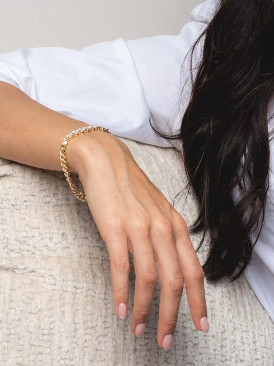 Trendsi necklace as affordable gold jewelry for beachwear on a woman’s hand with light pink nails