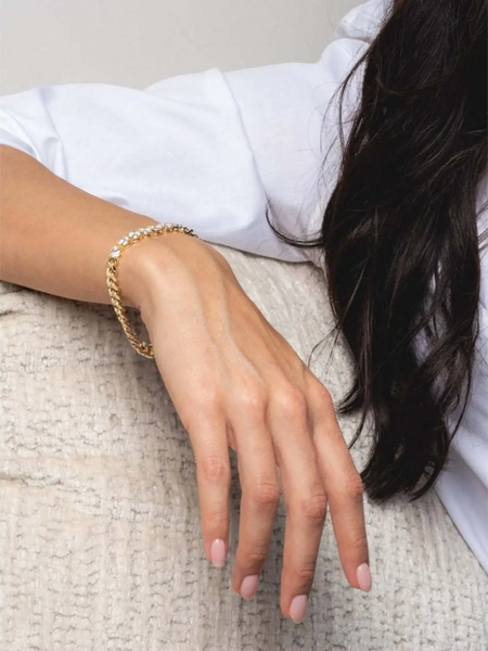 Trendsi necklace as affordable gold jewelry for beachwear on a woman’s hand with light pink nails