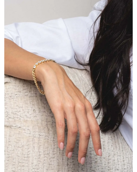 Trendsi necklace as affordable gold jewelry for beachwear on a woman’s hand with light pink nails