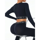 Trendsi branded leggings and tank outfit in black with long sleeves and sporty waistband sitting on a chair
