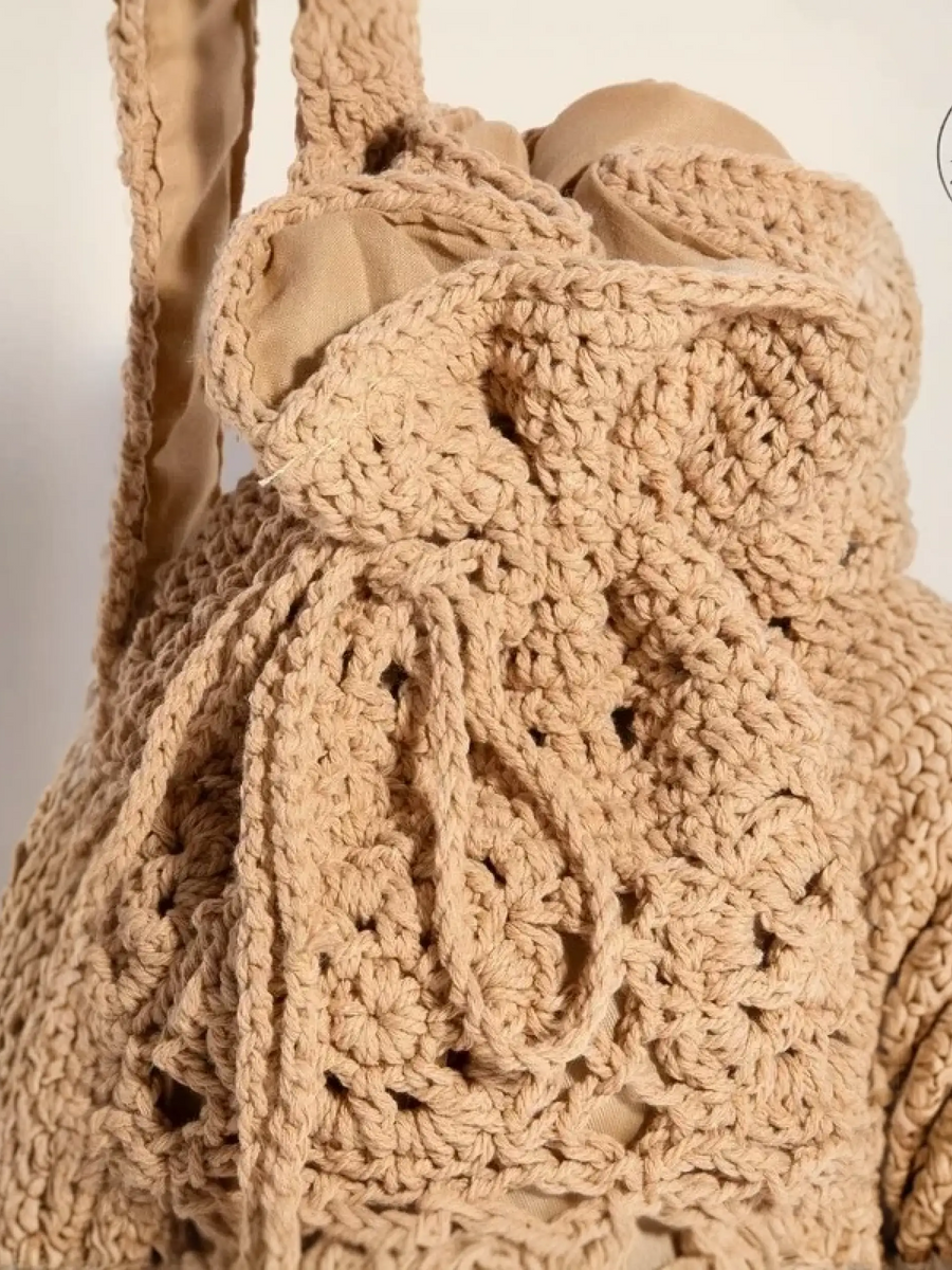 Beige crochet knit shoulder bag with intricate braided drawstring for boho beach vibes