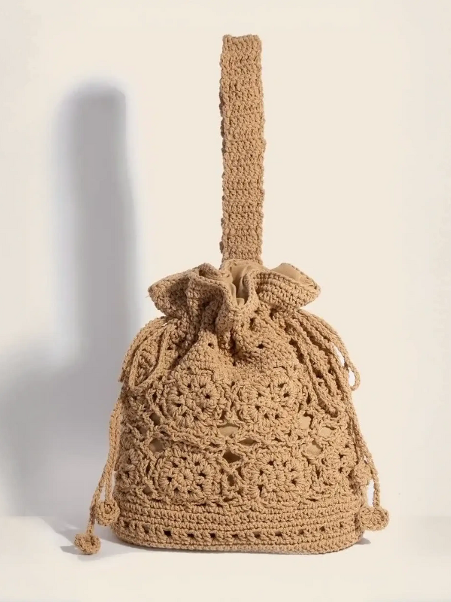 Crochet knit shoulder bag with intricate braided drawstring and handle for boho style