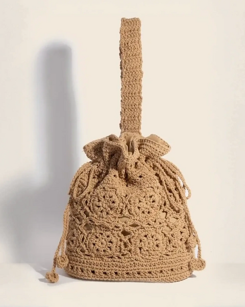 Crochet knit shoulder bag with intricate braided drawstring and handle for boho style
