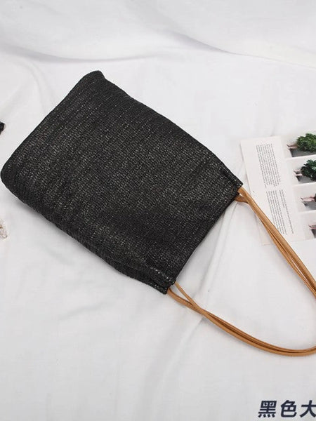 Black woven tote bag with brown handles perfect for stylish straw totes and beach days