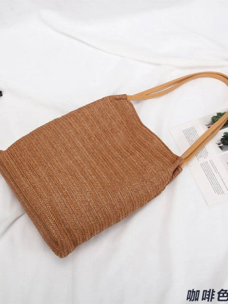 Brown woven straw tote with leather straps perfect for stylish beach days and straw totes