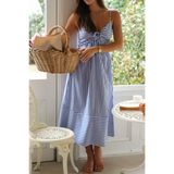 woman blue and white striped beach midi dress with spaghetti straps and a bow detail
