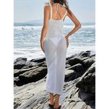 Babe Beachwear white delicate sheer swimsuit cover up worn by woman standing on rocky beach