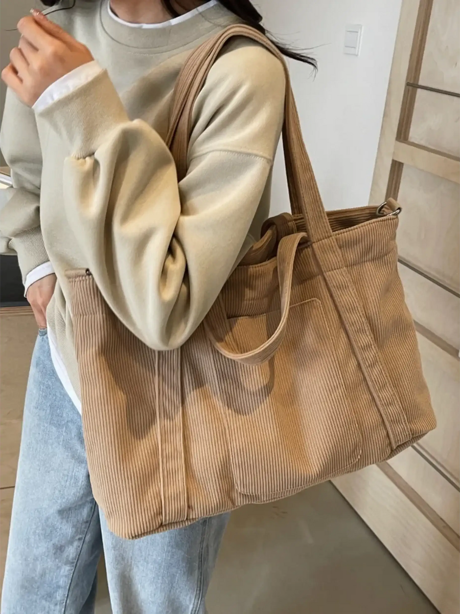 Lightweight Ladies duffle bag in beige corduroy fabric carried over shoulder by woman