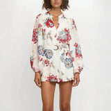 Babe Beachwear belted floral summer romper with long sleeves and vibrant red and blue flower print