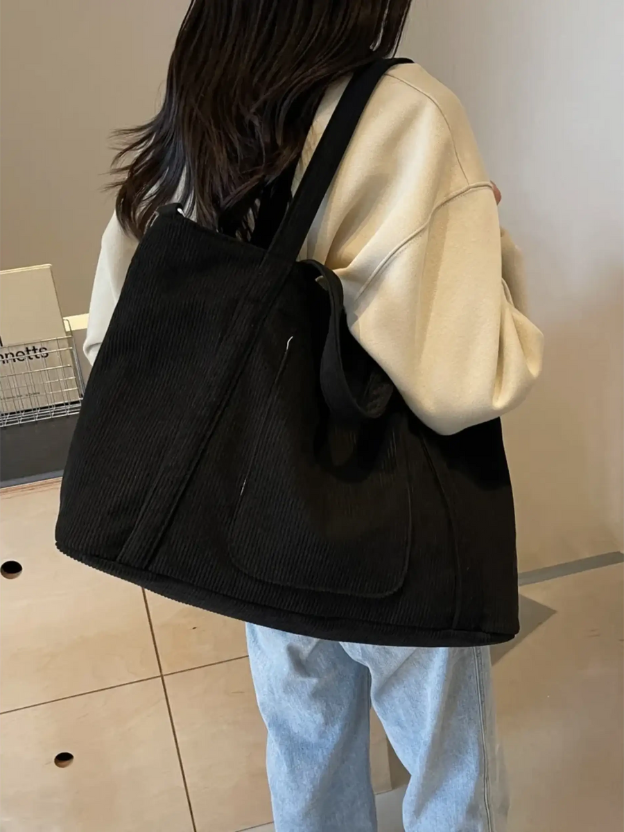 Black lightweight Ladies duffle bag by Babe Beachwaer carried over shoulder with casual outfit