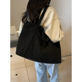 Black lightweight Ladies duffle bag by Babe Beachwaer carried over shoulder with casual outfit