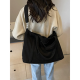 Babe Beachwaer black lightweight Ladies duffle bag carried on shoulder by woman in casual outfit
