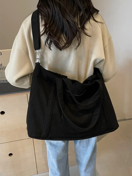 Babe Beachwaer black lightweight Ladies duffle bag carried on shoulder by woman in casual outfit